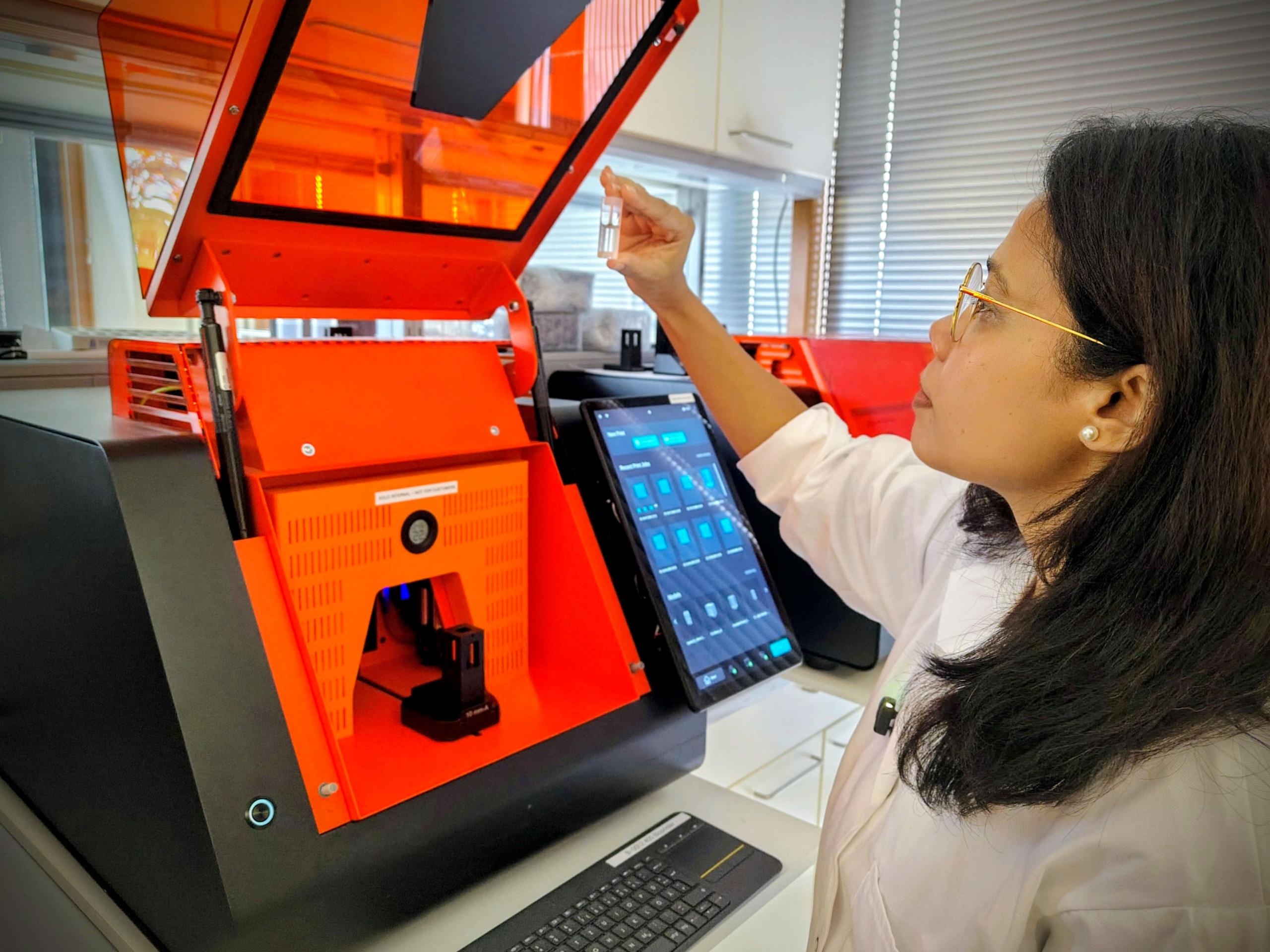 Researcher inspecting a printed part at the Xube²