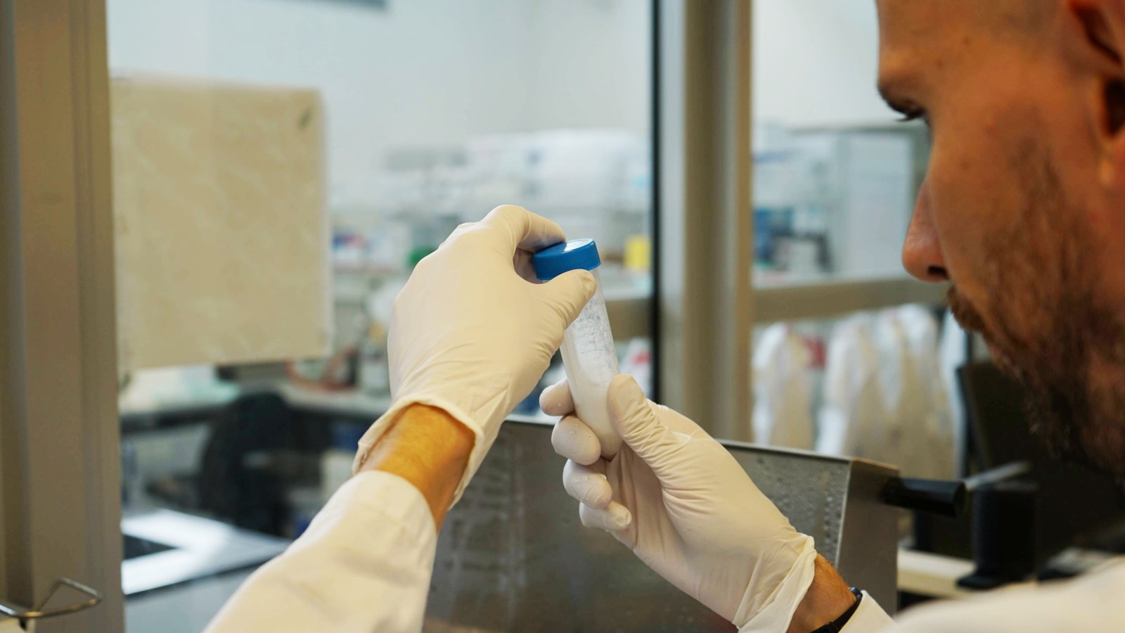 xolo chemist in gloves inspecting a tube of GelMA in the lab